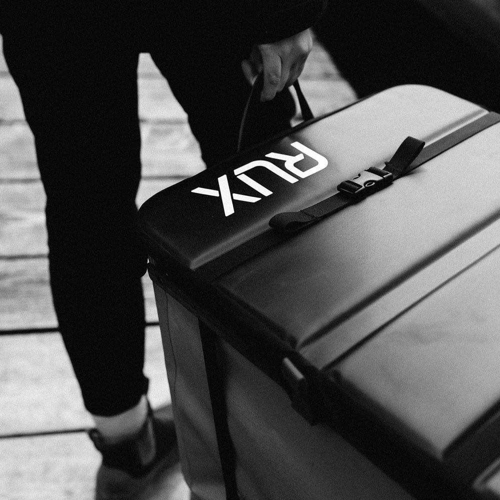 Rux 70L waterproof gear bag in black being carried for outdoor travel and storage