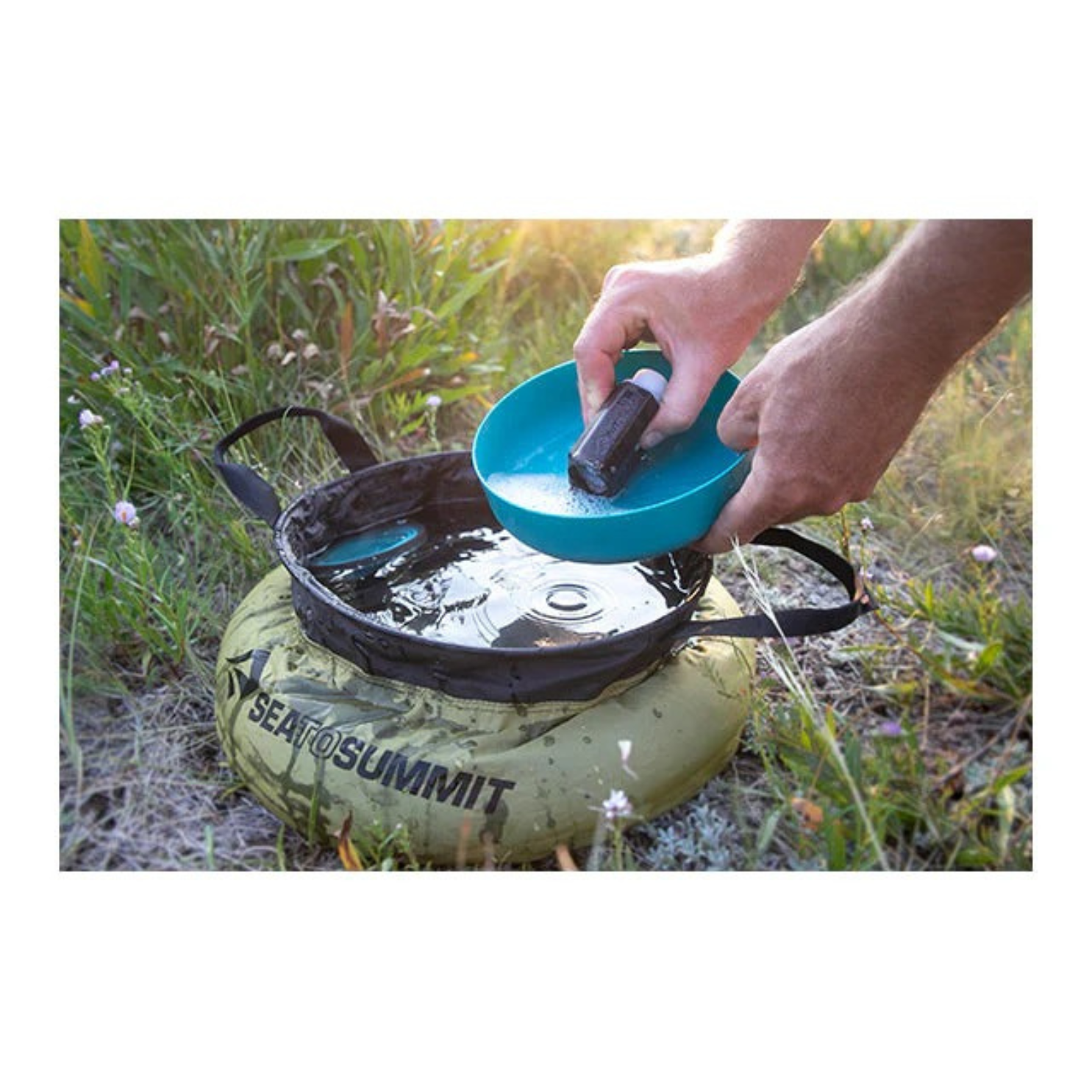 Sea to Summit Camp Kitchen Clean-Up Kit in use washing dishes outdoors with collapsible sink at campsite