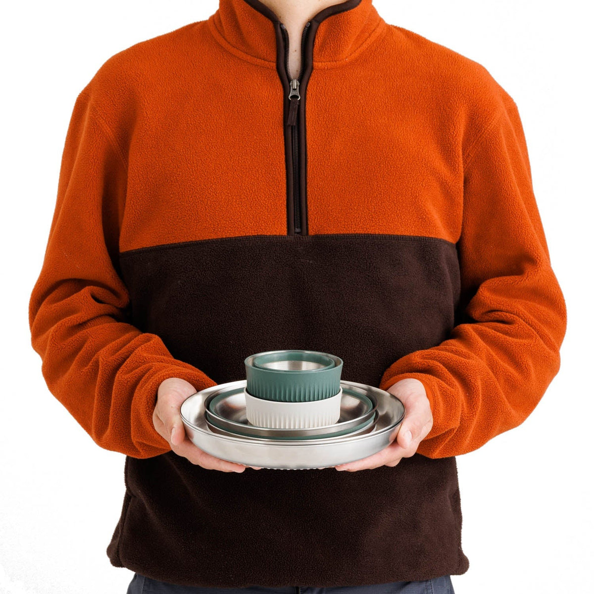 Person holding the stacked Sea to Summit Detour dinnerware set showing its compact nested size