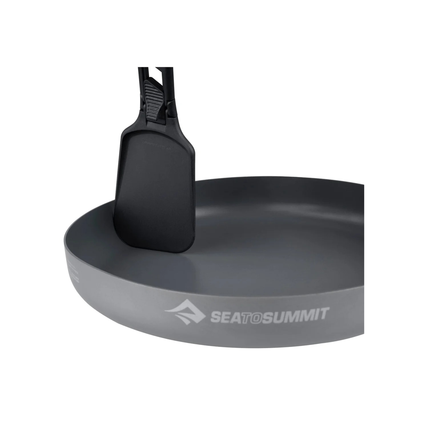 Compact folding camping spatula standing in non-stick frying pan for outdoor cooking