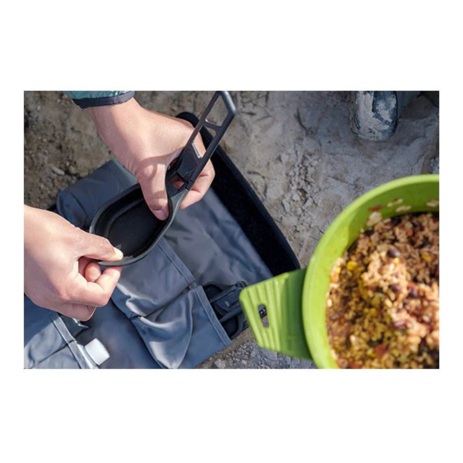 Sea to Summit folding spoon being used for serving food at campsite with compact kitchen setup
