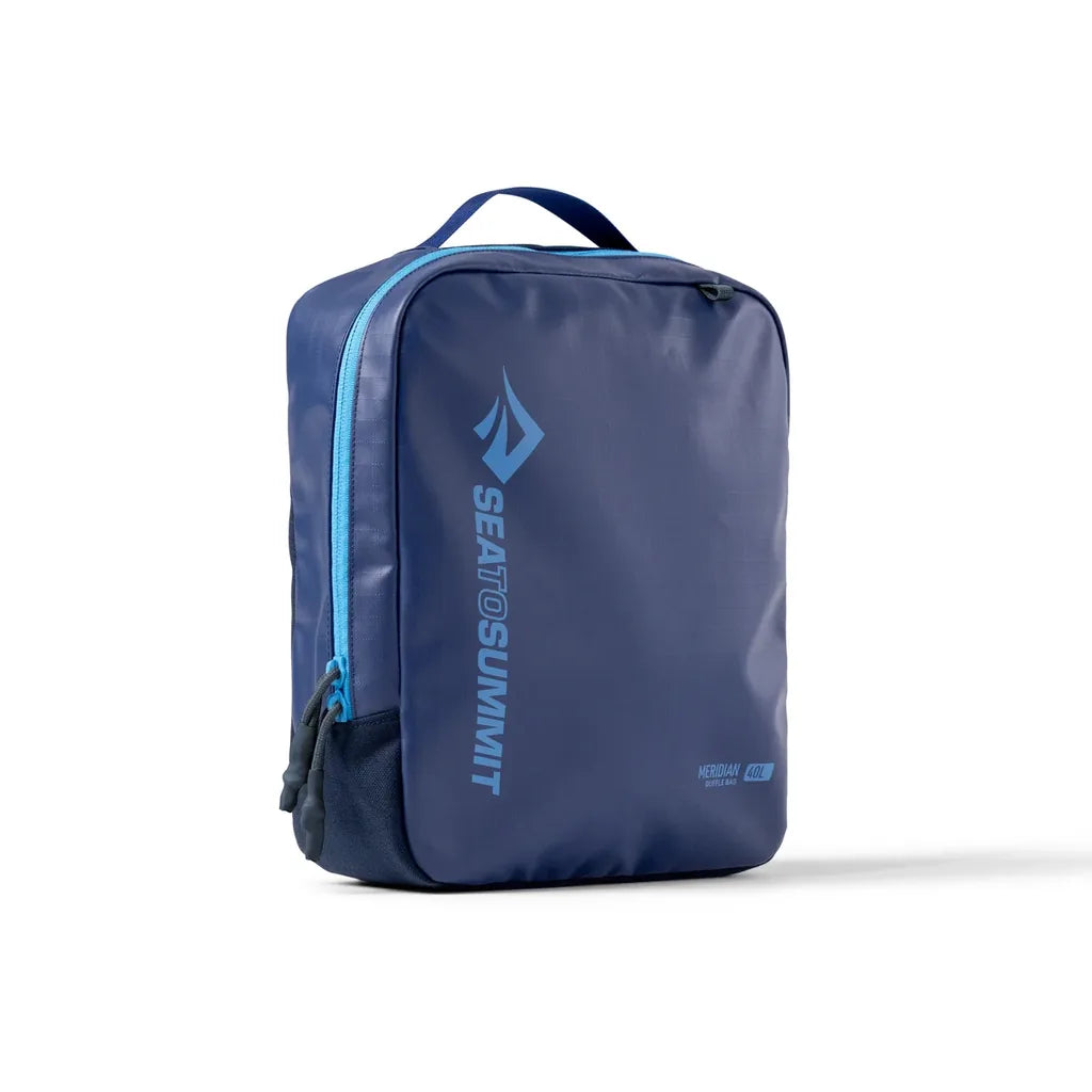 Front three-quarter view of a navy Sea to Summit Meridian Duffle Bag 40L with light blue zipper and carry handle