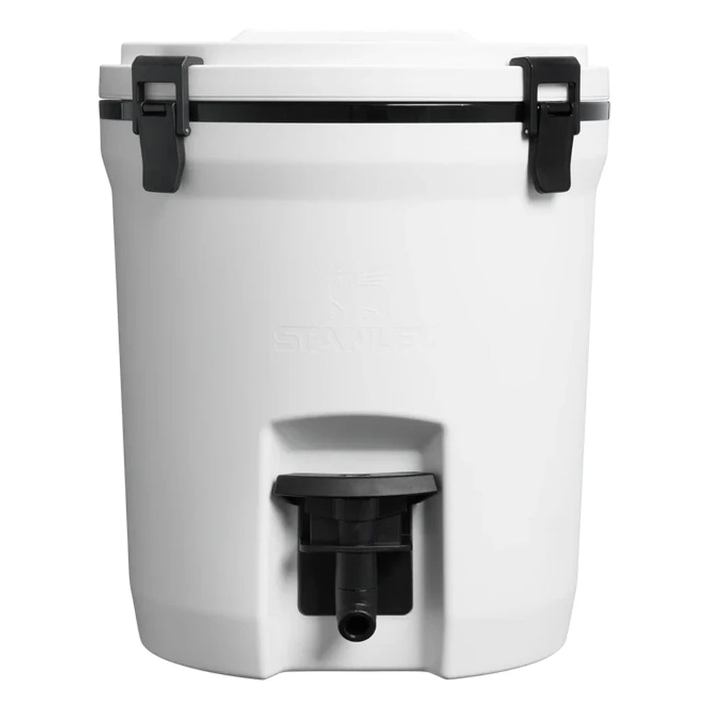 Stanley Adventure Fast Flow Water Jug 2 Gallon in Twilight front hero on white background showing navy blue cylindrical body with Stanley winged bear embossed logo, orange fast-flow spigot with lever handle at the front base, and orange latch hardware securing the lid