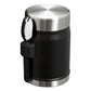 Stanley Adventure To-Go Food Jar and Spork 24oz in Matte Black top and side angle view on white background showing polished stainless steel lid, matte black jar body, black spork holder strap, and black spork clipped to the side
