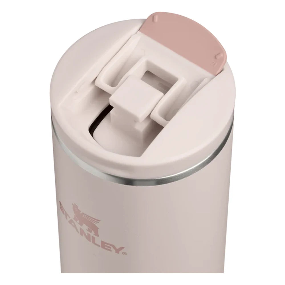 Stanley AeroLight Transit Bottle 20oz in Rose Quartz flip-top lid close-up detail on white background showing the blush pink lid flipped open revealing the drink opening with rose quartz plastic inner mechanism, press-button latch, and stainless steel trim ring at the neck with Stanley logo visible below