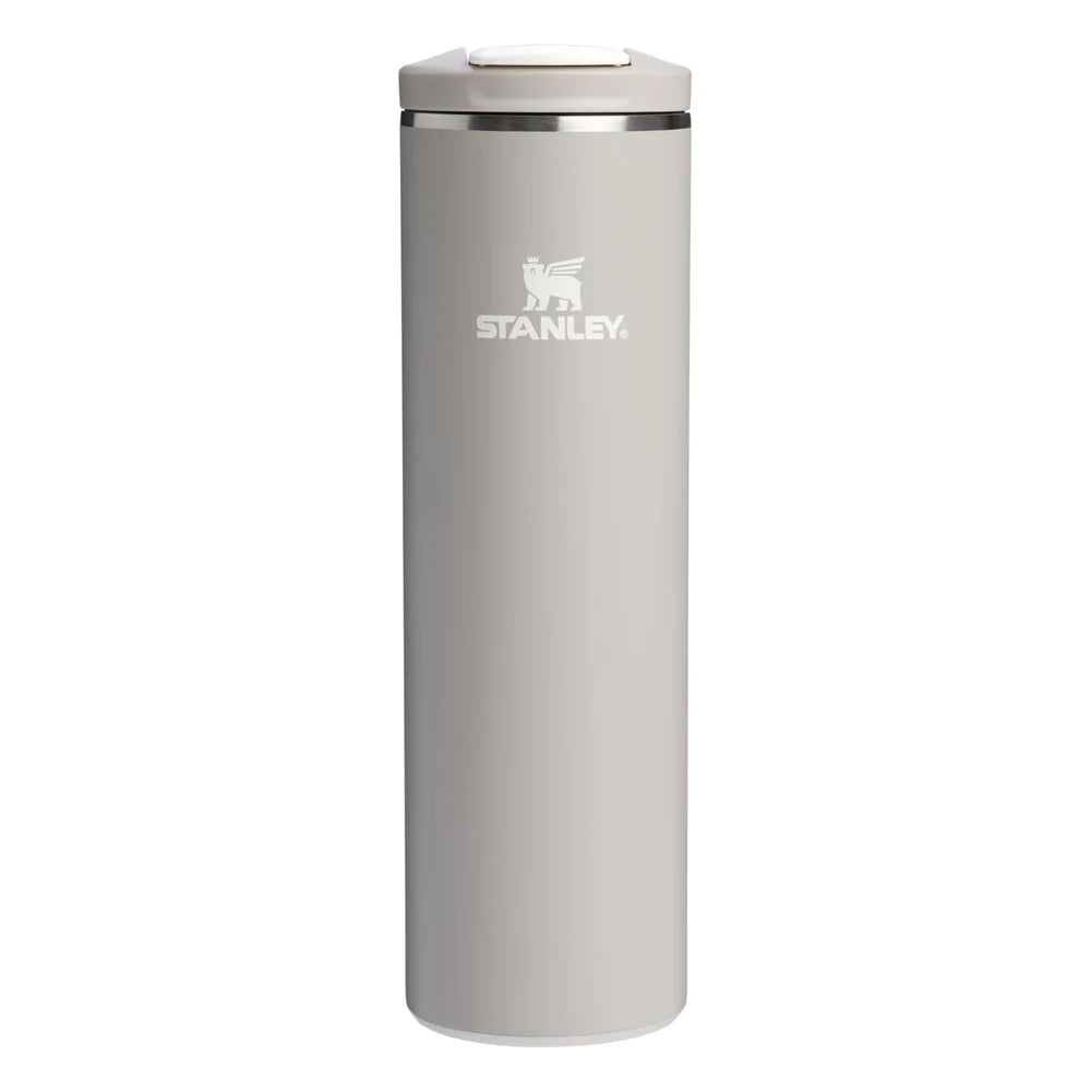 Stanley AeroLight Transit Bottle 20oz in Warm Gray front hero on white background showing slim warm gray matte cylindrical bottle with Stanley winged bear logo, stainless steel trim ring at the neck, and warm gray flip-top lid with press-button latch