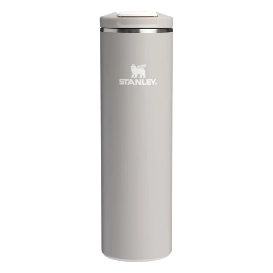 Stanley AeroLight Transit Bottle 20oz in Warm Gray front hero on white background showing slim warm gray matte cylindrical bottle with Stanley winged bear logo, stainless steel trim ring at the neck, and warm gray flip-top lid with press-button latch