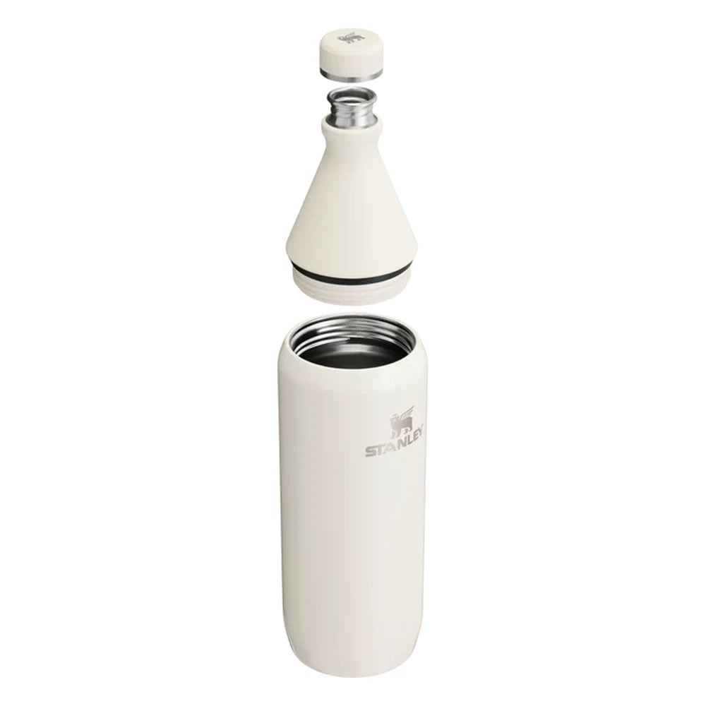 Stanley All Day Slim Bottle 34oz in Cream Gloss exploded view on white background showing all components separated: flat cap with Stanley bear icon floating above, the cone-shaped upper neck section with black sealing gasket and stainless steel threaded opening, and the cylindrical lower body with open stainless steel interior and Stanley logo