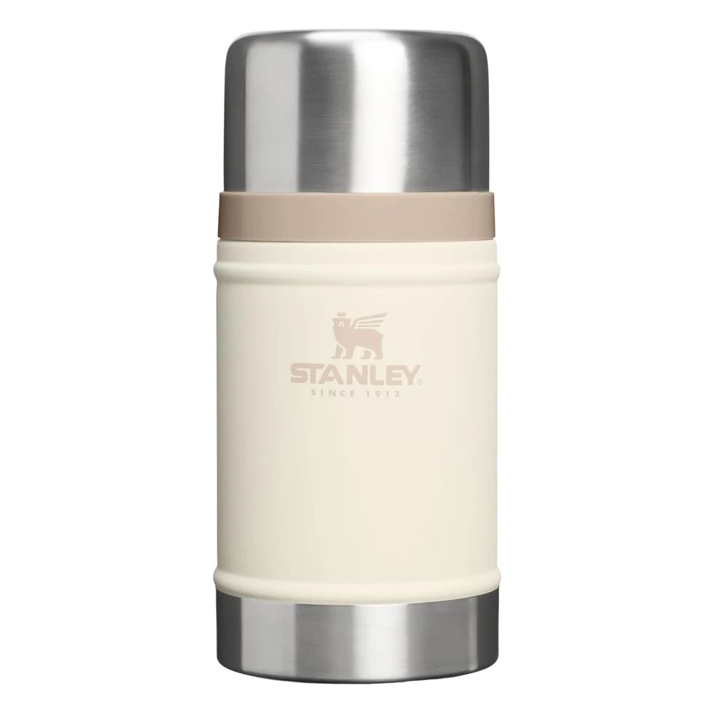 Stanley Classic Legendary Food Jar 24oz in Cream front hero on white background showing cream matte cylindrical body with Stanley Since 1913 winged bear logo, large polished stainless steel dome lid, tan beige rubber gasket ring at the lid-body junction, and brushed stainless steel base