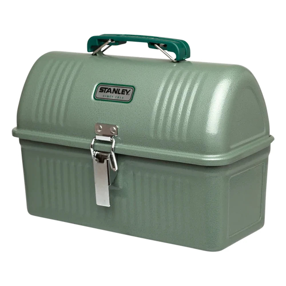 Stanley Classic Lunch Box 5.5QT in Hammertone Green three-quarter view on white background showing hammertone green metal dome-lid lunch box with ribbed top, green arched carry handle, white oval Stanley Since 1913 badge, and single silver metal latch buckle on the front face