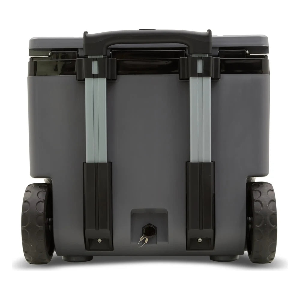 Stanley The Cold For Days Wheeled Outdoor Cooler 50QT in Charcoal Black back view on white background showing the fully extended two-stage aluminum telescoping handle with black grip, gray charcoal body with black lid trim, two large black all-terrain wheels with dimpled rubber tread, and drain plug with tethered cap at the bottom center