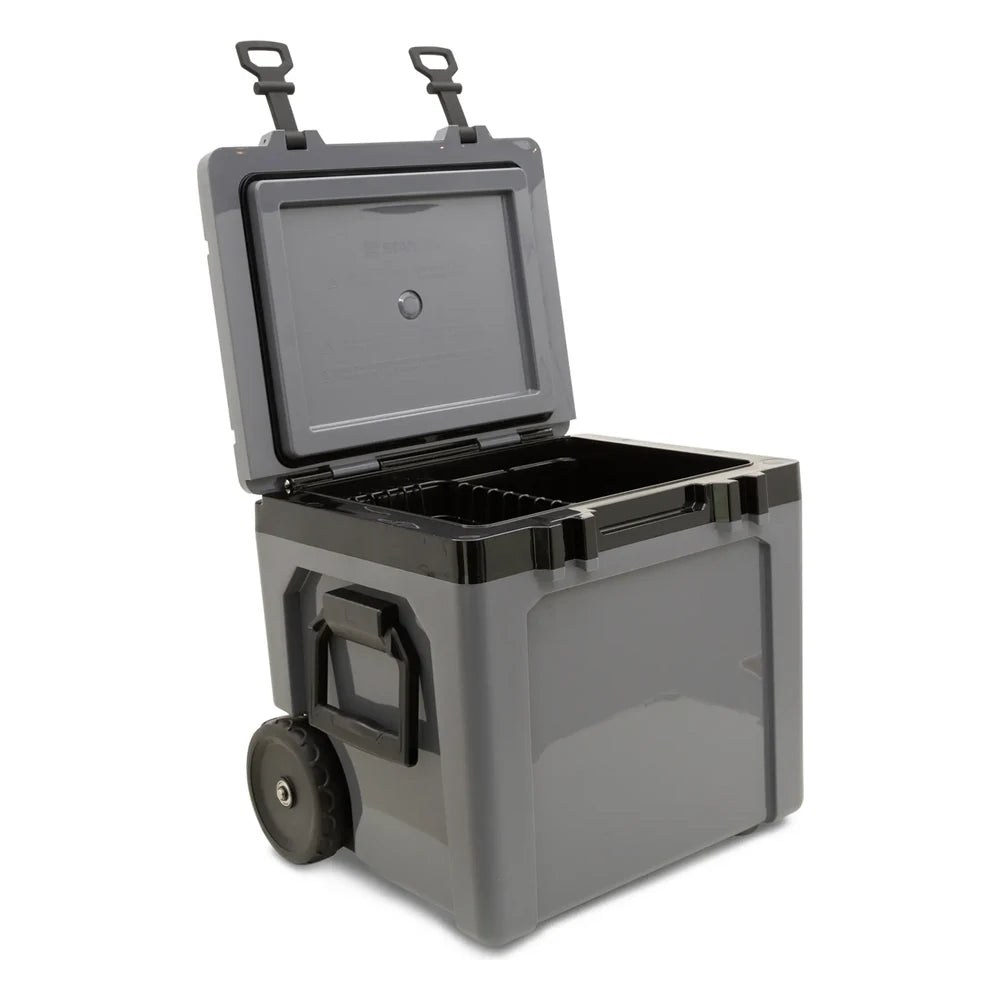 Stanley The Cold For Days Wheeled Outdoor Cooler 50QT in Charcoal Black side-angle open view on white background showing the gray charcoal body with lid fully hinged back, dark gray interior with black wire basket insert, black side carry handle, and large black all-terrain wheel at the base