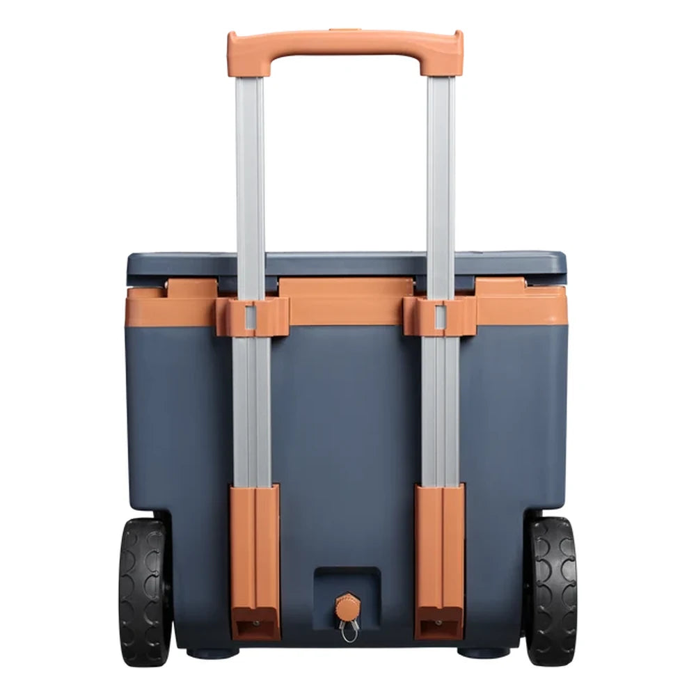 Stanley The Cold For Days Wheeled Outdoor Cooler 50QT in Twilight back view on white background showing the fully extended two-stage aluminum telescoping handle with orange grip, navy blue body, two large black all-terrain wheels, and drain plug with tethered cap at the bottom center