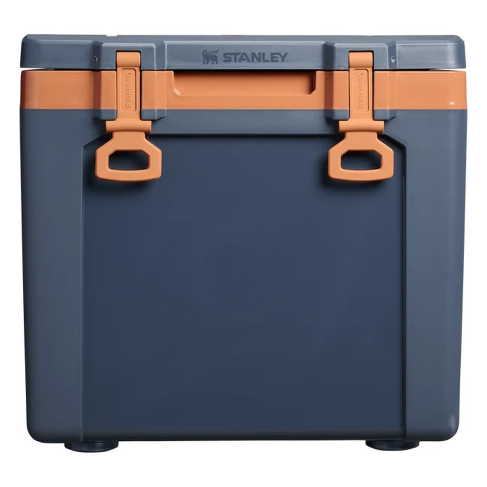 Stanley The Cold For Days Wheeled Outdoor Cooler 50QT in Twilight front hero on white background showing navy blue body with two orange D-ring latch handles and hinged lid, Stanley logo on top of lid, and orange lid trim accent