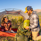Hiker packing Klymit Static V Summit Double sleeping pad into backpack at campsite