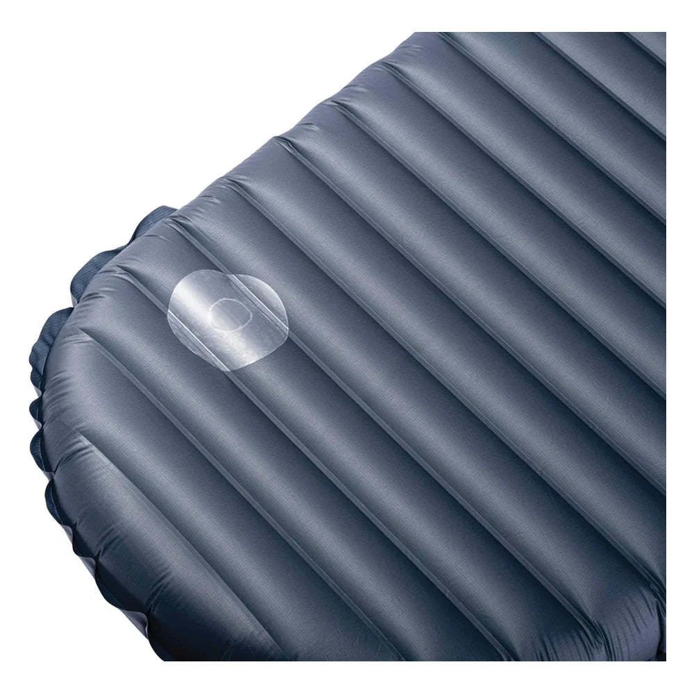 Close-up detail of Therm-a-Rest Instant Field Repair Kit clear adhesive patch applied to corner of inflated blue sleeping pad, showing transparent repair patch on ribbed pad surface